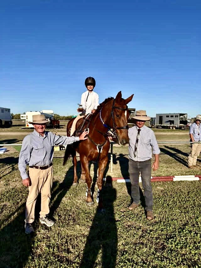 Ella Kilmartin is presented with the Keith Lowe memorial trophy for junior showjumping.