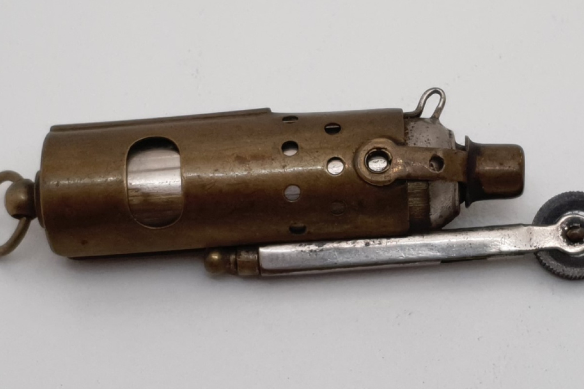 The brass windproof lighter with the shield down and snuffer in place. Photos by the Nyngan Museum.